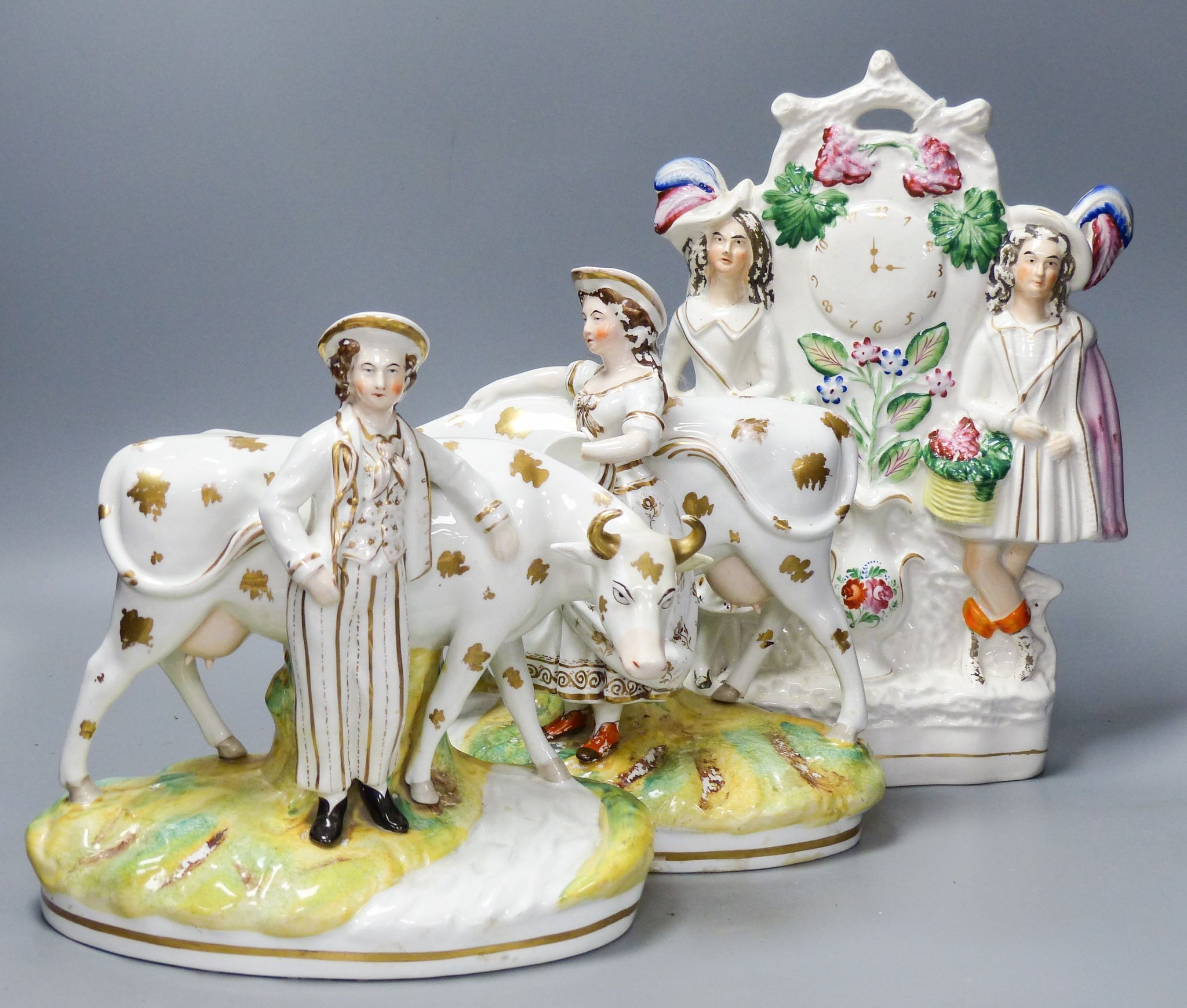 A pair of 19th century Staffordshire cow groups and a similar flatback, tallest 33 cm